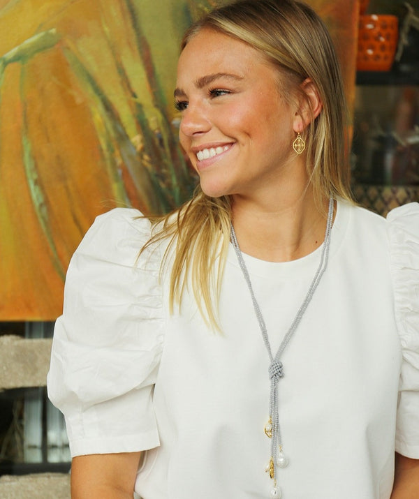 long gray pearl & shield necklace being worn